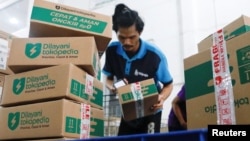 FILE - An employee prepares packages for shipping at a warehouse of e-commerce giant Tokopedia in Jakarta, Indonesia, Aug. 31, 2022. 