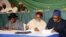 ARCHIVES - (de g. à dr.) Le président nigérian de l'époque, Goodluck Jonathan, le général Abdulsalami Abubakar (ex-chef de l'État), et le candidat à la présidence de l'époque, Mohammadu Buhari, signent un engagement en faveur d'élections apaisées, le 26 mars 2015 à Abuja.