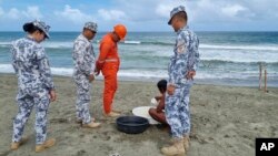 En esta foto proporcionada por la Guardia Costera de Filipinas, el personal de la Guardia Costera revisa a un pescador mientras realiza una patrulla a lo largo de la costa en la provincia de Ilocos Norte, en el norte de Filipinas, mientras se preparan para los posibles efectos del tifón Mawar el lunes 29 de mayo de 2023.