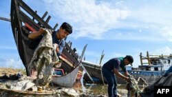 University students clean up plastics and other debris washed ashore at a port in Banda Aceh, Indonesia.