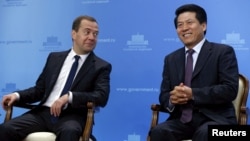 资料照：2015年时任俄罗斯总理的梅德韦杰夫与李辉共同出席一次会议。
