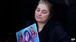 A mourner attends the funeral of a person who died in a wedding hall fire, in Hamdaniyah, Iraq, Sept. 27, 2023.