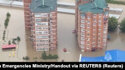 Para petugas SAR menggunakan perahu karet mengevakuasi warga yang terjebak banjir di Kota Ussuriysk, Rusia, Sabtu, 12 Agustus 2023. (Foto: Kementerian
Gawat Darurat/handout via Reuters)