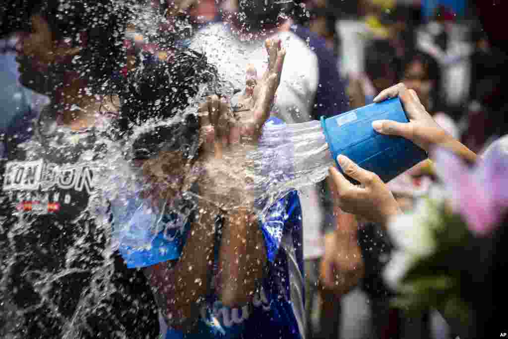 A man reacts as a bucket of water is splashed on him during the Songkran water festival to celebrate the Thai New Year in Prachinburi Province, Thailand, April 13, 2024. 