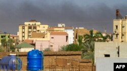 Smoke rises behind buildings in Khartoum amid ongoing fighting between the forces of two rival generals, on May 16, 2023.