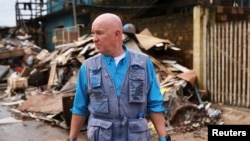 Andrew Harper, climate advisor for the UN refugee agency known as UNHCR, visits a neighborhood partially destroyed by the floods that hit Porto Alegre, in the state of Rio Grande do Sul, Brazil, June 23, 2024.