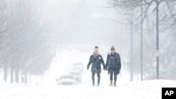 FILE - University of Kentucky students Courtney Wiseman, left, and Abby Lerner walk home after studying on campus in Lexington, Ky., Feb. 16, 2015. 