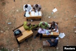Election workers examine papers at a vote collation center that had been stormed by unknown assailants earlier in the day in Alimosho, Lagos, Nigeria, Feb. 26, 2023.