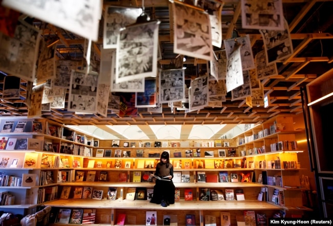 Seorang perempuan membaca buku di bilik Book and Bed, sebuah akomodasi yang dipadukan dengan kafe buku di mana para tamu dapat tidur di Tokyo, Jepang (Foto: REUTERS/Kim Kyung-Hoon)