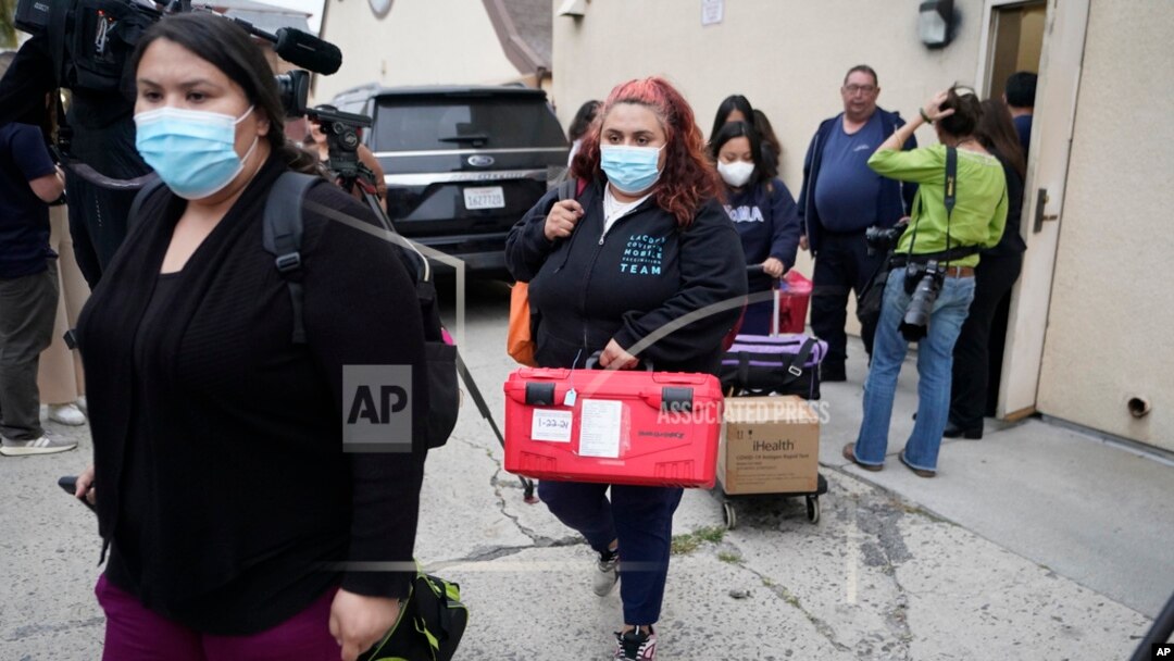 Funcionarios del servicio público de Operaciones de Emergencias del Condado Los Ángeles salen de la Iglesia católica croata de San Antonio, en Los Ángeles, tras evaluar a varios migrantes alojados en la ciudad el miércoles 14 de junio de 2023.