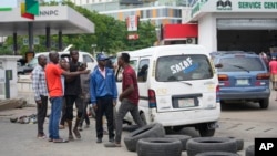 FILE: People argue with each other as cars queue to buy fuel at the Nigerian National Petroleum Company Limited petrol station in Lagos, Nigeria, Tuesday , May 30, 2023. On May 31, NNPC tripled prices as the state subsidy ended. 