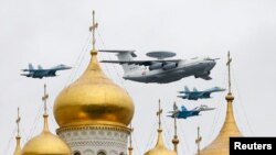 资料照片：在一次阅兵式彩排期间，俄罗斯空军一架A-50预警机与战斗机一道编队飞过红场和克里姆林宫。(2010年5月6日)