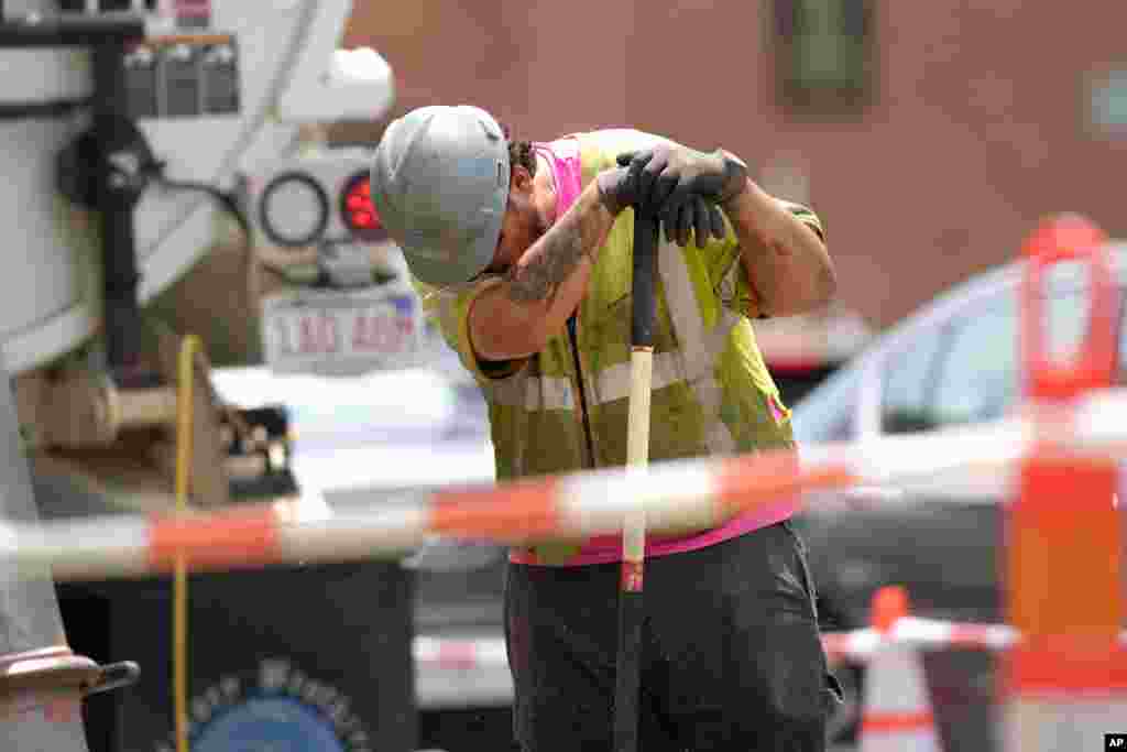 Seorang pekerja menyeka wajahnya ketika bekerja di sebuah jalur distribusi gas di Boston, Massachusetts di tengah suhu yang mencapai 32&deg; C, Kamis, 20 Juni 2024. (Foto: Steven Senne/AP Photo)