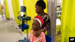 A woman, accompanied by her daughter, waits to be treated at a Doctors Without Borders emergency room in the Cite Soleil neighborhood of Port-au-Prince, Haiti, April 19, 2024.