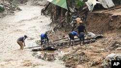 Men salvage parts from their destroyed home following heavy rains caused by Cyclone Freddy in Blantyre, southern Malawi, March 15, 2023. 