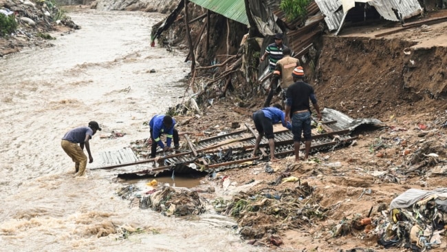 FILE - Men salvage parts from their destroyed home following heavy rains caused by Cyclone Freddy in Blantyre, southern Malawi, March 15, 2023.