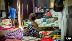 FILE - An elderly patient with an advanced stage of AIDS sits on her bed at a community hospital in Bangui, Central African Republic, Jan. 27, 2022.