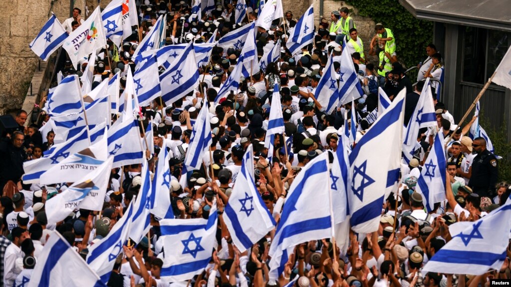 Israelis sing and dance with flags by Damascus gate to Jerusalem's Old City as they mark Jerusalem Day, in Jerusalem, May 18, 2023.