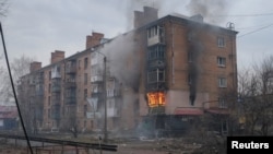 Smoke and flames rise from a building damaged by a Russian military strike, amid their attack on Ukraine, in the front line city of Bakhmut, in Donetsk region, Ukraine, Feb. 27, 2023.