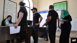 Voters line up to get their ballots at a polling station during a referendum in Tashkent, Uzbekistan, April 30, 2023.