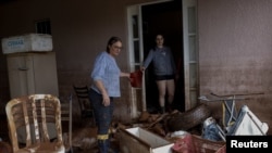 ARCHIVO - Geni Teresinha Mulinari, de 54 años, y su hija Paola Mulinari, de 26, comparten un balde mientras limpian su casa durante las inundaciones en Eldorado do Sul, estado de Rio Grande do Sul, Brasil, el 11 de mayo de 2024. Esta vez el mal clima afectó Sao Paulo.