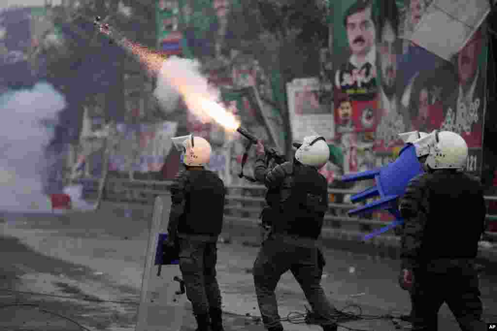 A riot police officer fires tear gas to disperse supporters of former Prime Minister Imran Khan during clashes outside Khan&#39;s residence, in Lahore, Pakistan.