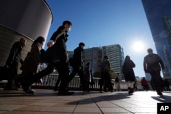 FILE - Para komuter berjalan menuju Stasiun Shinagawa di Tokyo, Rabu, 14 Februari 2024. (AP/Eugene Hoshiko)