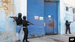 FILE — National Police stand guard outside the empty National Penitentiary after a small fire inside in downtown Port-au-Prince, Haiti, March 14, 2024.