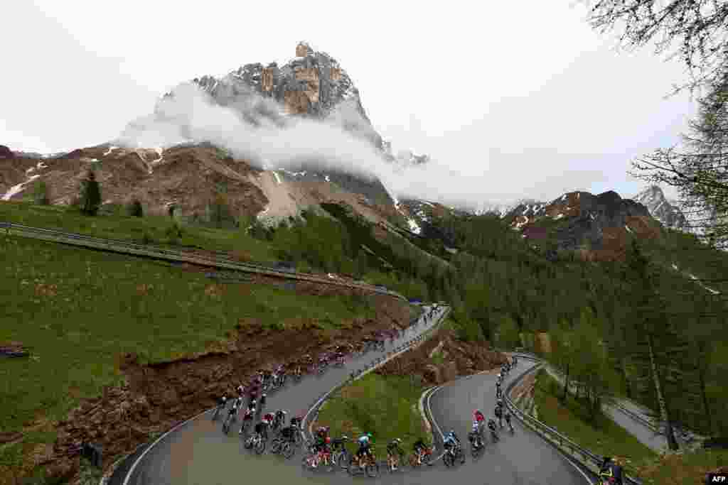 The pack rides a downhill curve in Passo Rolle during the 17th stage of the 107th Giro d&#39;Italia cycling race, 159km between Selva di Val Gardena and Passo del Brocon, Italy.