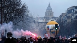Para pengunjuk rasa berbaris, dengan latar belakang monumen Pantheon di Paris, Prancis, Selasa, 7 Maret 2023. (AP/Lewis Joly)