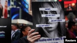 Seorang peserta aksi membawa poster yang berisi informasi tentang bahaya fentanil dalam sebuah aksi bersama di Times Square, New York, pada 21 Agustus 2023. (Foto: Reuters/Shannon Stapleton)