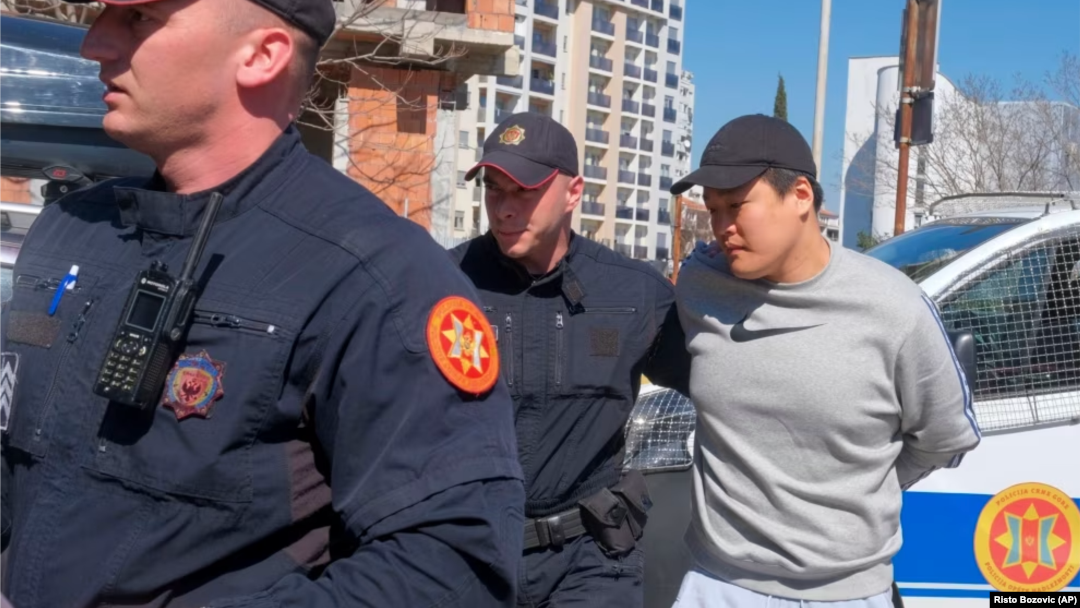 Crnogorska policija privodi pojedinca za koga se veruje da je Do Kvon (Foto: AP/Risto Bozovic)