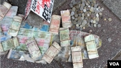 Discarded old Zimbabwean currency notes and coins are seen on the pavement of a street in Harare on April 15, 2024.  (Columbus Mavhunga/Voice of America)