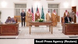 Saudi Foreign Minister stands along with other officials as representatives of the Sudanese army and rival paramilitary Rapid Support Forces sign an agreement for a seven-day ceasefire.