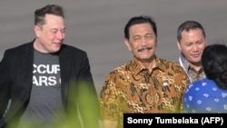 Miliarder teknologi Elon Musk berjalan bersama Menteri Koordinator Kemaritiman dan Investasi Luhut Binsar Pandjaitan saat tiba di bandara Internasional Ngurah Rai di Denpasar, 19 Mei 2024. (Foto: AFP/Sonny Tumbelaka)