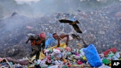 Waste pickers Salmaa and Usmaan Shekh, right, search for recyclable materials during a heat wave at a garbage dump on the outskirts of Jammu, India, June 19, 2024.