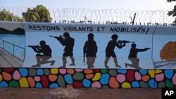 FILE - A mural urging people to stay vigilant and mobilized is seen in Ouagadougou, Burkina Faso, on March 1, 2023. 