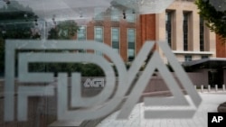 FILE - A U.S. Food and Drug Administration building is seen behind FDA logos in Silver Spring, Maryland, on Aug. 2, 2018.