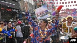 Revelers take part in mass water fights on the eve of Songkran, or Thai New Year, on Khao San Road in Bangkok, Thailand. (Photo by Lillian SUWANRUMPHA / AFP)