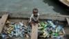FILE - A child in a canoe with plastic bottles for recycling in Lagos, Nigeria, Nov. 8, 2022. Negotiators at UNESCO in Paris for talks on global treaty to fight plastic pollution. 