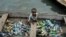 FILE - A child in a canoe with plastic bottles for recycling in Lagos, Nigeria, Nov. 8, 2022. Negotiators at UNESCO in Paris for talks on global treaty to fight plastic pollution. 
