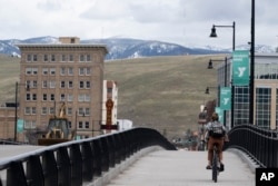 A cyclist rides over a bridge in Missoula, Montana, a state with a growing population due, in part, to relocating California residents, April 25, 2023.