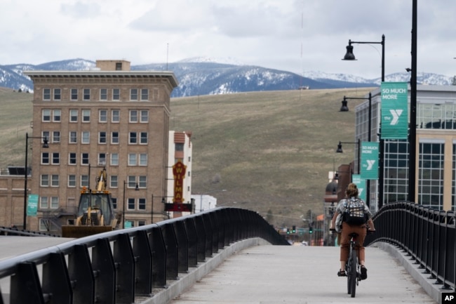 A cyclist rides over a bridge in Missoula, Montana, a state with a growing population due, in part, to relocating California residents, April 25, 2023.
