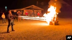 In this frame grab from video provided by Debbie McFarland, state Sen. Bill Eigel torches a pile of cardboard boxes at a “Freedom Fest” event in Defiance, Mo., Sept. 15, 2023. 