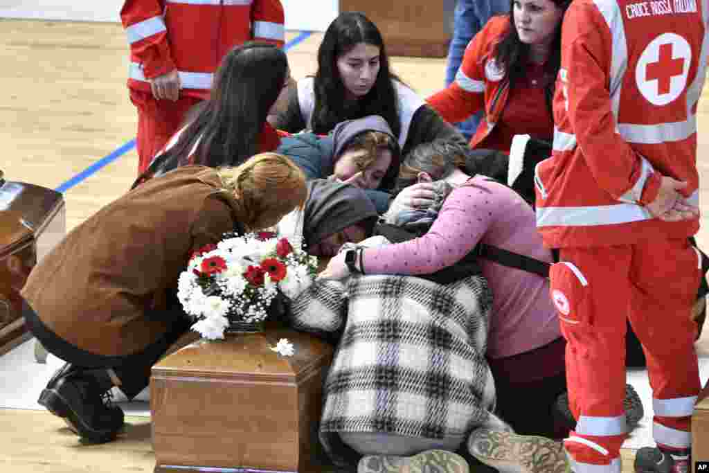 Relatives cry on the coffin of one of the victims of last Sunday&#39;s shipwreck at the local sports hall in Crotone, southern Italy.&nbsp;At least 67 people died when their overcrowded wooden boat broke apart in rough water just off a beach in Calabria.