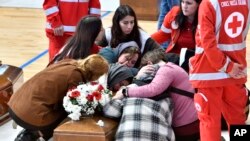FILE - Relatives cry on the coffin of one of the victims of last Sunday's shipwreck at the local sports hall in Crotone, southern Italy, March 1, 2023.