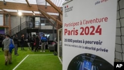 Job seekers line up to get application papers during an Olympics jobs fair in Paris on Dec. 14, 2023.
