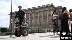 A police officer on a Segway patrols Sweden's parliament building as the terror threat level in Sweden is raised to four on a five-point scale, in Stockholm, Sweden, Aug. 17, 2023. (Fredrik Sandberg/TT News Agency/via Reuters)