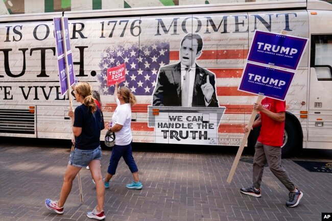 Los partidarios del expresidente Donald Trump caminan cerca del Foro Fiserv mientras continúa la preparación para el debate presidencial republicano el 22 de agosto de 2023 en Milwaukee, Wisconsin.