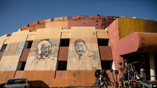 A mural depicting the Burkinabe filmmaker Idrissa Ouedraogo, center, is displayed at the headquarters of the Pan-African Film and Television Festival in Ouagadougou, Burkina Faso, Feb. 22, 2023.